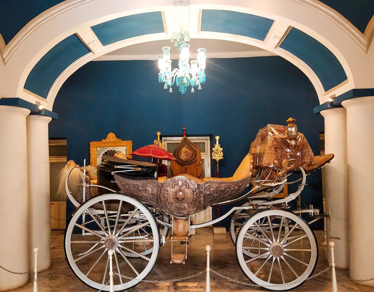 A royal carriage displayed in a hall of Jai Vilas Palace