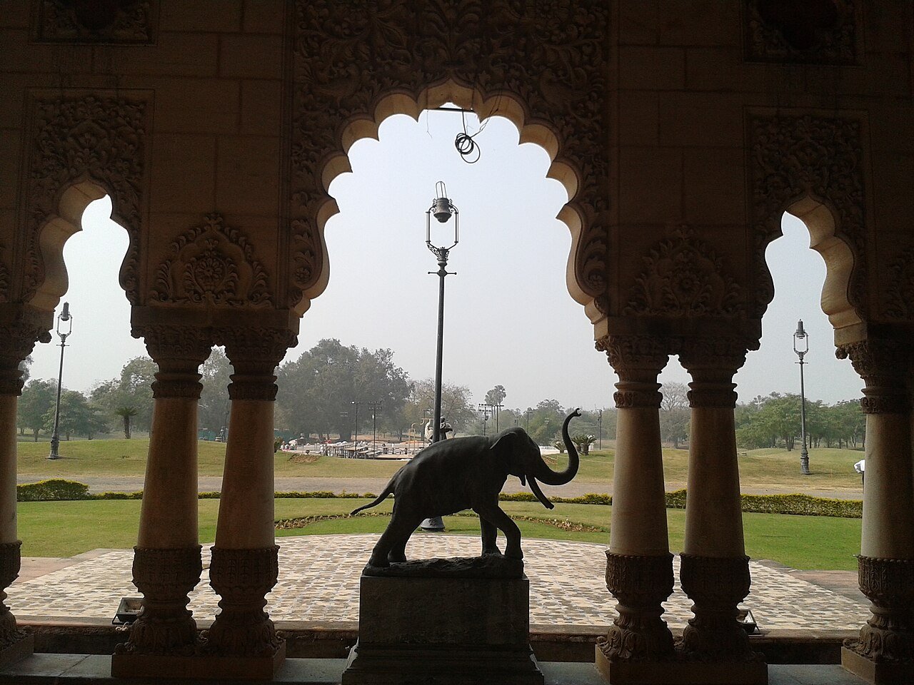 Arched window view with an elephant statue at Laxmi Vilas Palace